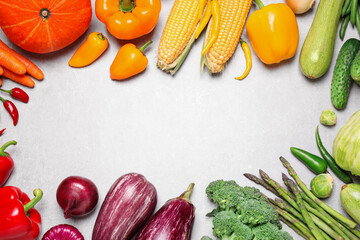 Frame of different fresh vegetables on grey table, flat lay. Space for text