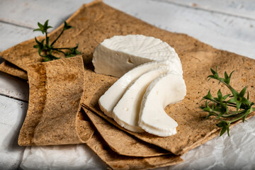 Cheese wheel, slices . Organic food. Still life, Adyghe cheese on pita bread and Basil leaves.