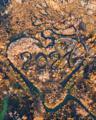 Heart shaped river in autumn forest with 2021 text as river. New year concept, aerial drone view