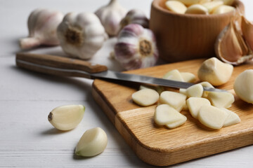 Fototapeta na wymiar Fresh chopped garlic on wooden board, closeup. Organic product