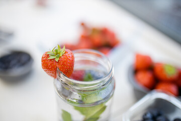 Strawberry on the edge of a mint and berries drink