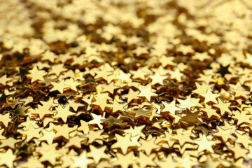 Shiny golden confetti stars, closeup. Christmas celebration