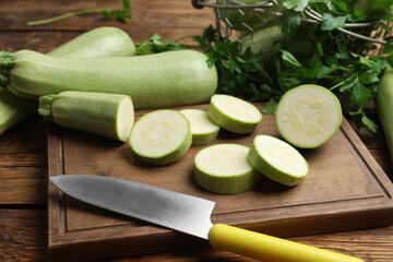 Ripe green zucchinis and parsley on wooden table