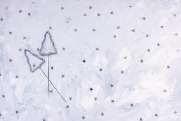 Sparkles and silver confetti stars on blue winter holiday background. Festive abstract backround. Birthday party, New Year celebration and preparation concept