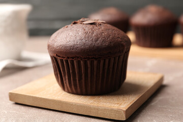 Delicious cupcake with chocolate crumbles on beige marble table, closeup