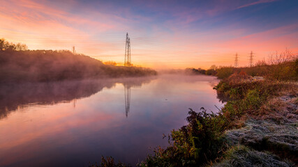 Autumn landscape with fog and frost with a river at sunrise