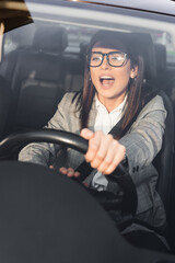  woman screaming and beeping while driving car and looking ahead on blurred foreground