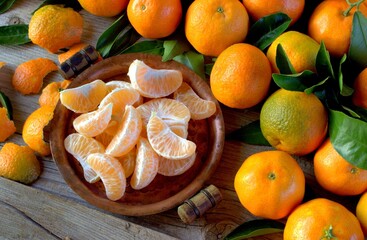 Fresh tangerines and slices on a wooden board. fruits background.