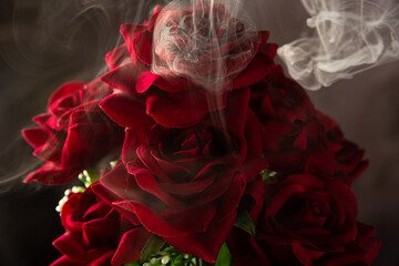 Naklejka premium Cascade of smoke beautifully covering a bouquet of fabric flowers, abstract background, selective focus.