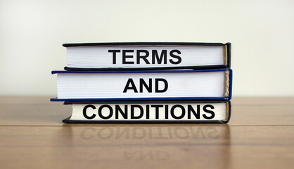 Terms and conditions symbol. Books with the text 'terms and conditions' on beautiful wooden table, white background. Business concept, copy space.