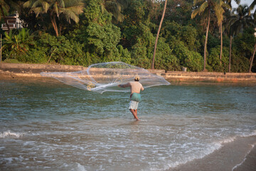 Goa/ India 09 November 2020 Unidentified Indian fisherman catch fish by throwing net at Baga Beach Goa