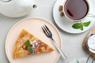 Slice of traditional apple pie served on light marble table, flat lay