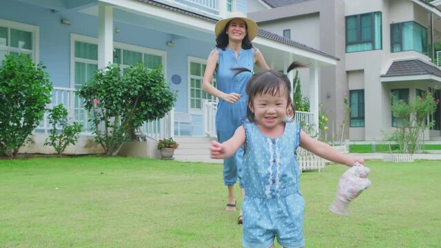 Asian young mother happy to see her daughter walking fluently.