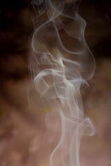 Smoke, beautiful shapes made by smoke from incense on dark background, selective focus.