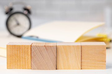 Wooden block and alarm clock on table close up