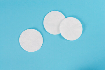 White organic cotton pads on a blue background.