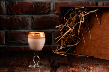 Whipped dalgona coffee on a dark background with copy space. Korean coffee drink. Horizontal composition