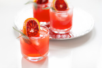 Blood orange cocktails with sage on white minimal background