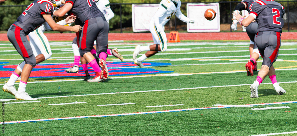 Wall mural quarterback lateraling the ball to running back during football game