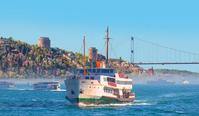 Fototapeta premium Rumeli Hisari (fortress) in to Bosphorus Sea - Water trail foaming behind a passenger ferry boat in Bosphorus, Istanbul, Turkey