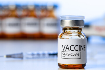 Covid-19 vaccine bottle with a syringe on lab table