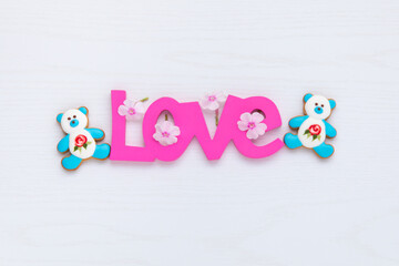 Coposition with Love word and two bear shape cookies.