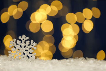 Fototapeta na wymiar Beautiful decorative snowflake against blurred festive lights, space for text