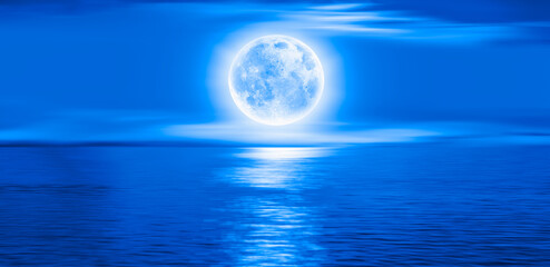 Night sky with moon in the clouds , blue sea in the background "Elements of this image furnished by NASA