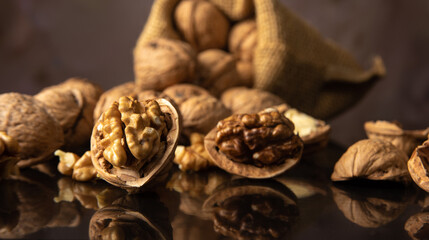 Nuts, details of nuts scattered on a black reflective surface, abstract background, selective focus.