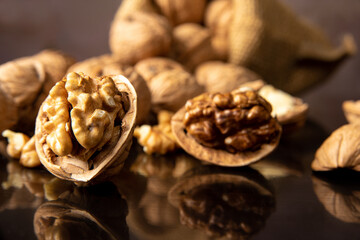 Nuts, details of nuts scattered on a black reflective surface, abstract background, selective focus.