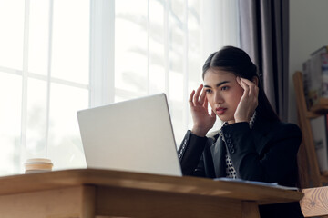 Stressed business Asian woman with palm on face in her office