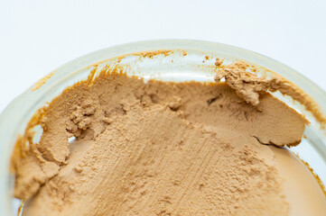 Brown skin care cream in a round jar