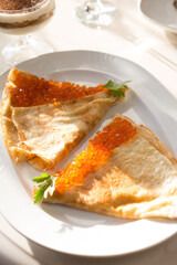 Pancakes served with red caviar