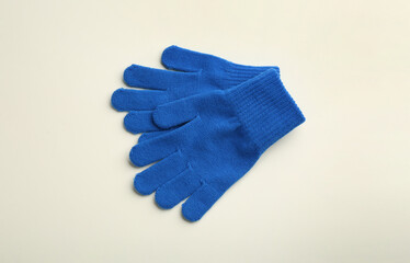 Pair of stylish woolen gloves on beige background, flat lay