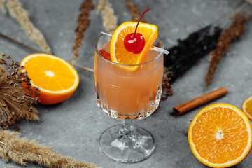 Mulled wine in glass glasses with apples orange and cinnamon. Hot Christmas drink on a grey...