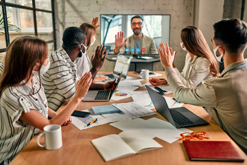 Online video training with video conference and business team for Covid-19. Business people wearing face mask, meeting, discussing, brainstorming ideas for investment in office during coronavirus