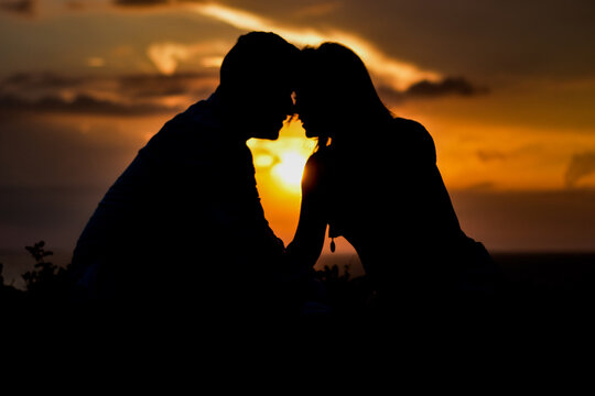 Pareja rom&aacute;ntica contraste frente al mar frente al sol d&aacute;ndose amor bes&aacute;ndose amanecer atardecer sunset