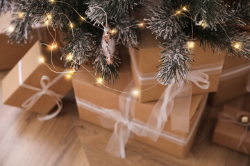 Fototapeta na wymiar Beautiful decorated Christmas tree with gifts in room, closeup