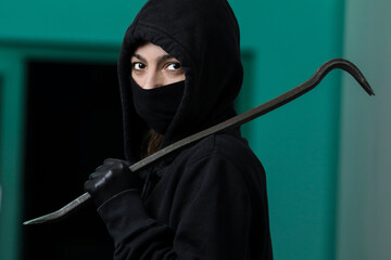 Thief broke into the apartment. House robbery by woman in a black jacket and black mask and...