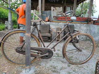 Old bicycle leaning on wood