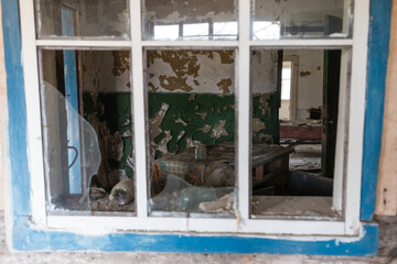 Old broken window in abandoned village of Chernobyl zone