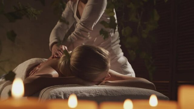 Young and beautiful woman gets massage therapy in the spa salon. Healthy lifestyle and body care concept.