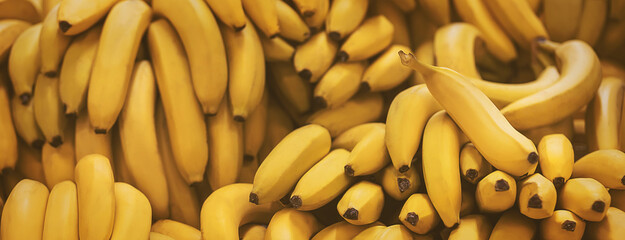 Delicious ripe yellow bananas are in the grocery store. Harvest of sweet tropical fruits. Background. ©  Valeri Vatel