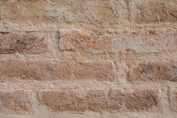 Fototapeta premium Uneven brick wall with cracked bricks, wall empty with space for text and a background