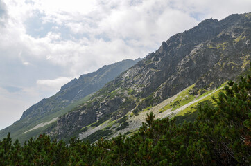 One of the peaks of the High Tatra mountains in Slovakia surrounded by forested mountains and trees in the foreground