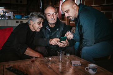 Son showing his elderly parents how to make a video call. Real life