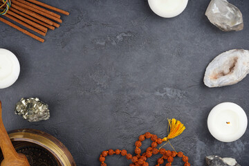 Singing bowl, heailng gemstones, candles, mala beads, incense frame on gray concrete background. Meditation, spirituality concept. Top view, flat lay, copy space