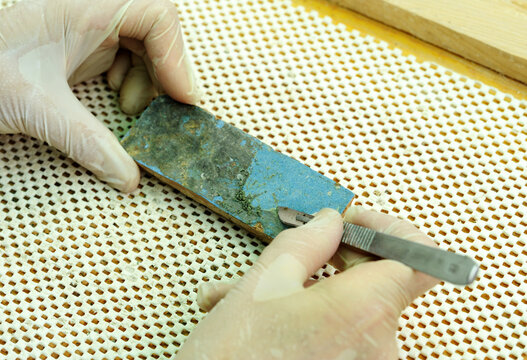 Limpieza a mano de un azulejo antiguo con escalpelo. Restauraci&oacute;n y conservaci&oacute;n de cer&aacute;mica antigua