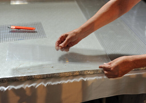 Manipulación de un panel de policarbonato transparente sobre un panel sandwich de fibra de vidrio. Trabajos de restauración y conservación