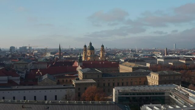Aerial Drone flight towards Theatine Church, Munich, Yellow Cathedral in big German City on beautiful Winter Day with clear sky and few clouds